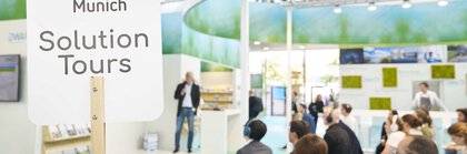 People taking part in a presentation at an exhibition stand as part of the IFAT Munich Solution Tours.