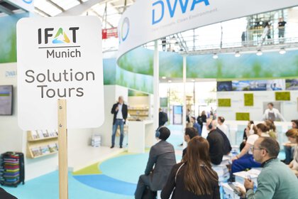People taking part in a presentation at an exhibition stand as part of the IFAT Munich Solution Tours.