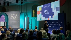 Bühnenansicht beim SZ Wirtschaftsgipfel mit Publikum; auf einer großen Leinwand ist ein IFAT-Munich-Banner zu sehen. 