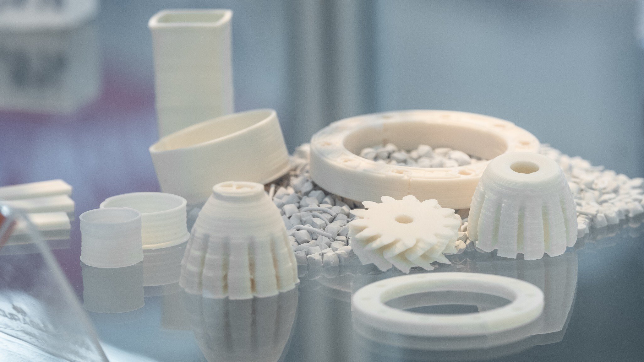 Close-up view of several bright circular exhibits produced using 3D printing and lying on a transparent surface.