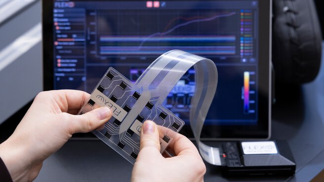 Flexible Leiterfolie mit integrierten Sensoren vor Analyse-Software auf Bildschirm
