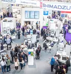 Bird's eye view of an exhibition stand where people talk to each other