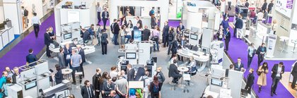 Bird's eye view of an exhibition stand where people talk to each other