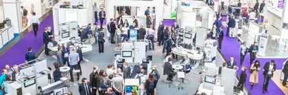 Vogelperspektive auf einen Messestand an dem Menschen miteinander reden