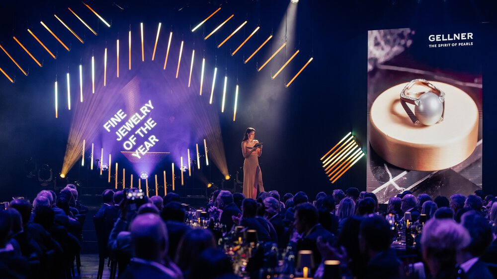 Eine Frau auf der Bühne überreicht die Auszeichnung 