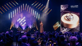 Eine Frau auf der Bühne überreicht die Auszeichnung 