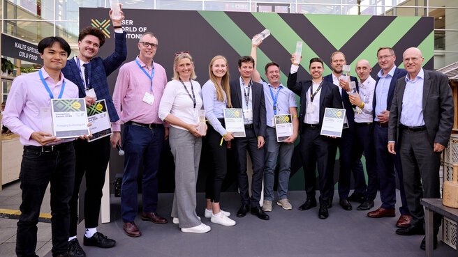 Die Überreicher und die Gewinner des Innovation Awards mit ihren Trophäen und Urkunden in der Hand auf der Bühne stehend - insgesamt 12 Personen.
