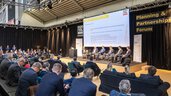 A panel discussion with six participants on stage and a large audience in the Planning & Partnerships Forum at EXPO REAL.