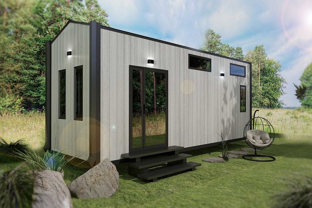 Modernes Tiny-House mit weißer Außenwand und dunklen Zierleisten, auf einer Rasenfläche mit einem Hängesessel und Felsen in der Nähe.