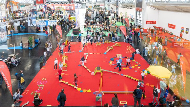 Blick von oben auf große Kinderspielfläche in einer Messehalle
