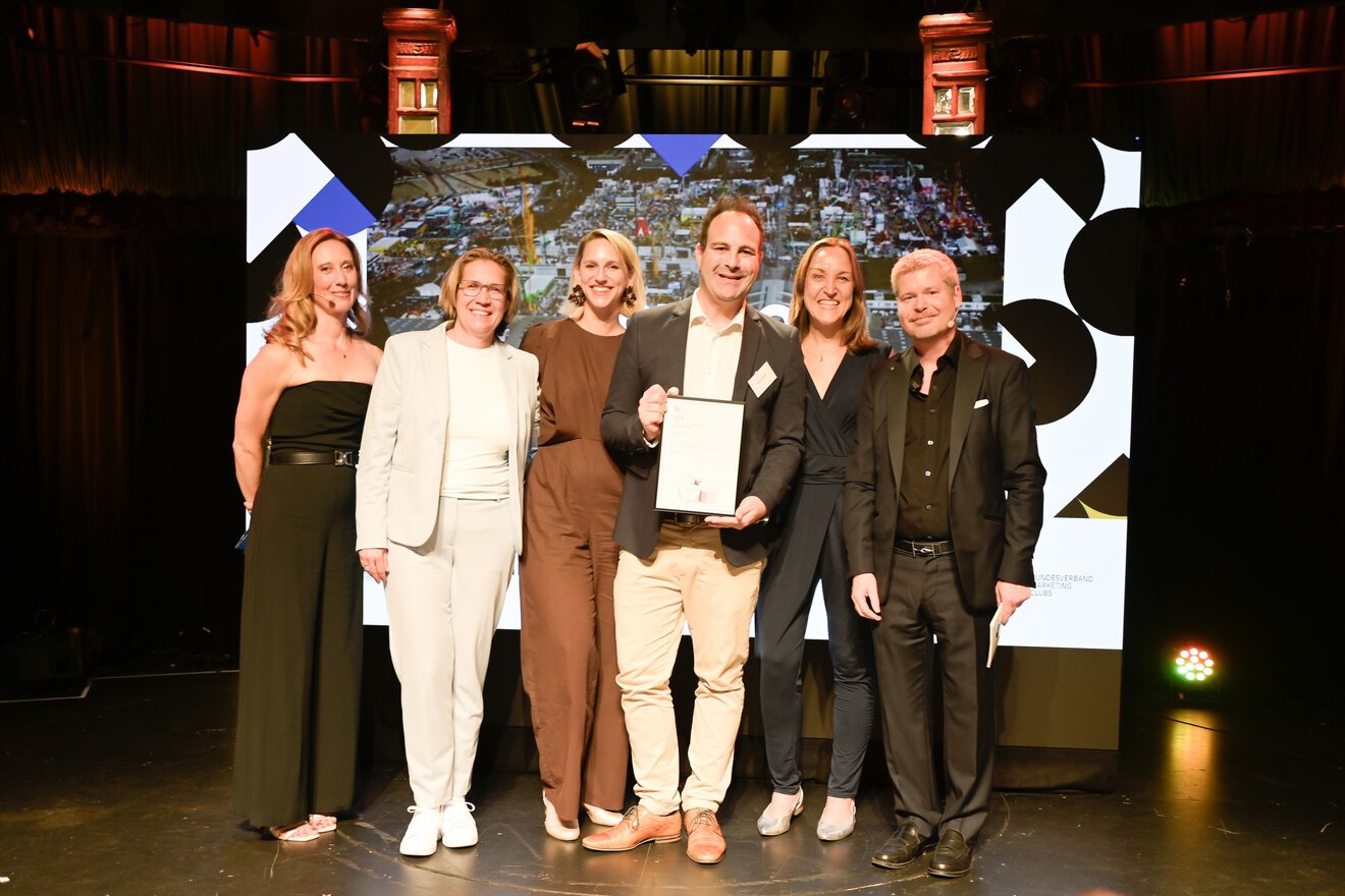 Award Zeremonie der bauma 2025, 6 Personen mit Urkunde auf Bühne, DPOK26 Gewinner, BoB Silber