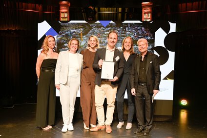Award Zeremonie der bauma 2025, 6 Personen mit Urkunde auf Bühne, DPOK26 Gewinner, BoB Silber