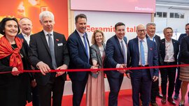 Eine Gruppe von Menschen in Geschäftskleidung lächelt und schneidet ein rotes Band bei einer Veranstaltung der ceramitec 2024 durch.