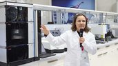 a woman in a lab coat gives a lecture