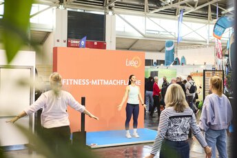 Trainerin leitet eine Fitness-Session auf der Mitmachfläche der Messe 
