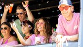 Fünf Menschen in rosa Hemden, die bei einer Veranstaltung im Freien lächeln und mit Seifenblasen spielen.