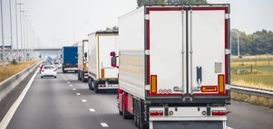 Mehrere Lastwagen fahren auf einer zweispurigen Autobahn.