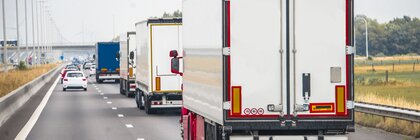 Mehrere Lastwagen fahren auf einer zweispurigen Autobahn.