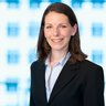 Smiling woman with shoulder-length brown hair in a business suit.