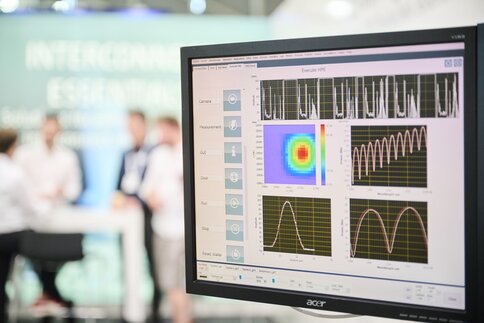 Close-up of a computer screen displaying diagrams and colored measurement data representing measurements from optical communication technology.