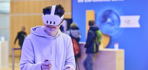 Man tests a virtual reality application with headset and controllers in the VR Experience Zone at bauma 2025.