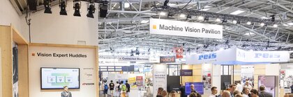 Einen Überblick über den Machine Vision Pavilion Bereich auf der automatica mit vielen Besucher auf der Fläche und einem gleichzeitig stattfindenden Vortrag