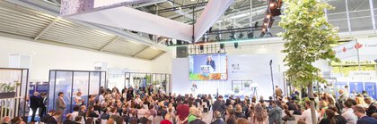 Teilnehmer einer Präsentation auf der Blue Stage während der IFAT Munich in einer großen Messehalle.