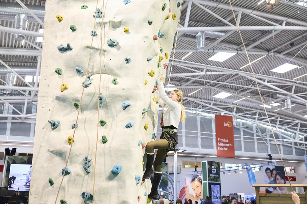 Visitor climbs the indoor climbing tower at f.re.e 2025.
