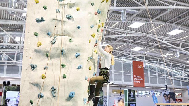 Visitor climbs the indoor climbing tower at f.re.e 2025.