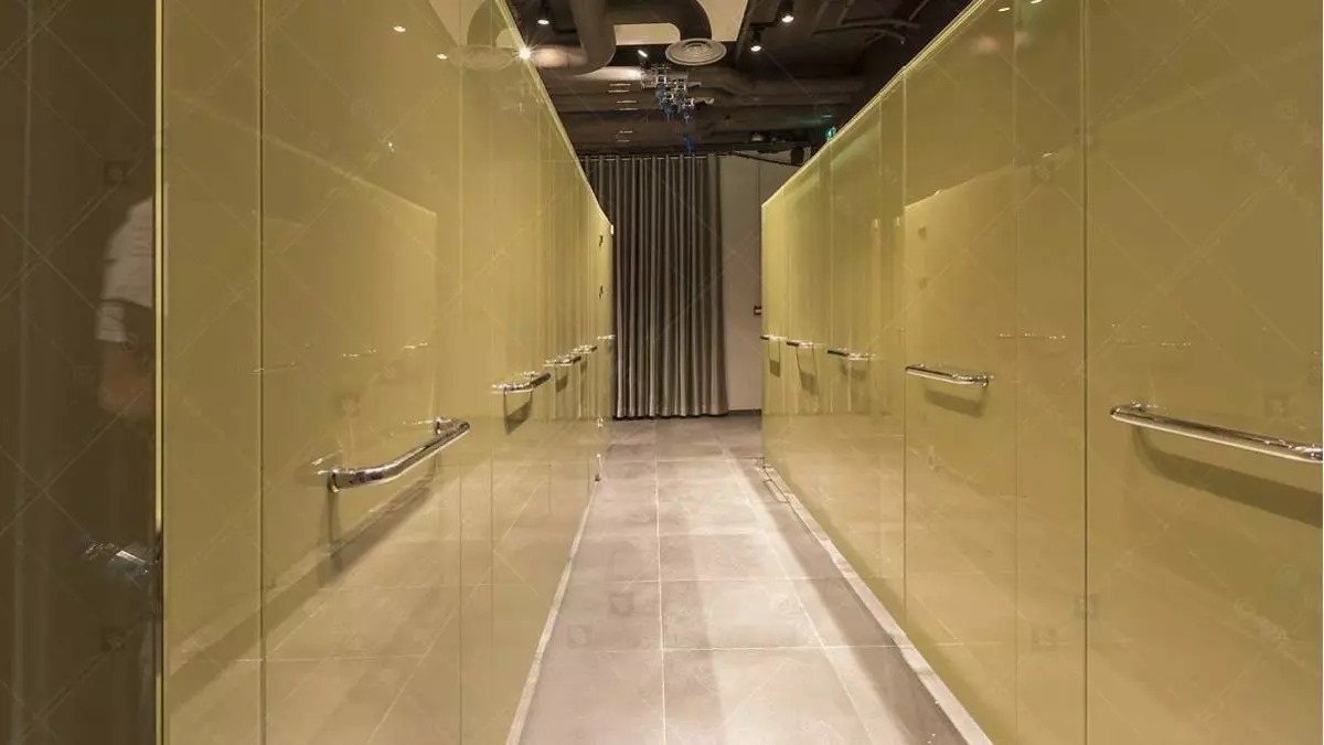 The shower area is primarily made of glass, with 21 EVOCUBICLES and wall cladding made of EVOKERAM R glass in two RAL shades.